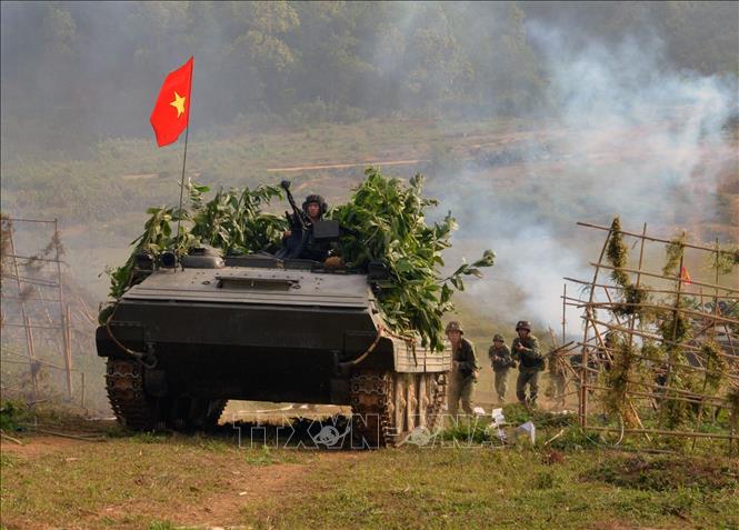 Xây dựng phòng thủ quân khu, khu vực phòng thủ vững chắc toàn diện, hợp thành phòng thủ đất nước; củng cố, tăng cường tiềm lực quốc phòng vùng chiến lược, trọng điểm, biển, đảo, khu vực biên giới, địa bàn xung yếu. Trong ảnh: Xe tăng Lữ đoàn 406, Sư đoàn bộ binh 316 (Quân khu 2) dẫn bộ binh vượt cửa mở đánh chiếm đầu cầu trong cuộc diễn tập chiến thuật có bắn đạn thật một bên hai cấp có hiệp đồng với các lực lượng vũ trang địa phương, dân quân tự vệ, thiết giáp, thông tin... năm 2015. Ảnh: Trọng Đức - TTXVN