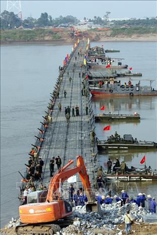 Xây dựng thực lực, tiềm lực quốc phòng; xây dựng lực lượng vũ trang nhân dân vững mạnh, có sức chiến đấu cao, làm nòng cốt bảo vệ Tổ quốc. Trong ảnh: Binh chủng Công binh lắp đặt cầu phao quân sự qua sông Hồng nhằm giảm tắc nghẽn giao thông nghiêm trọng trên cầu Thăng Long trong thời gian sửa chữa, tháng 11/2009. Ảnh: Trọng Đức - TTXVN