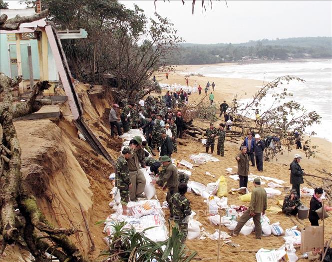 Quân đội luôn kề vai sát cánh cùng nhân dân khắc phục hậu quả thiên tai, lũ lụt. Trong ảnh: Lực lượng bộ đội Quảng Ngãi cùng nhân dân tham gia đắp kè chắn sóng biển xâm thực. Ảnh: Thanh Long - TTXVN