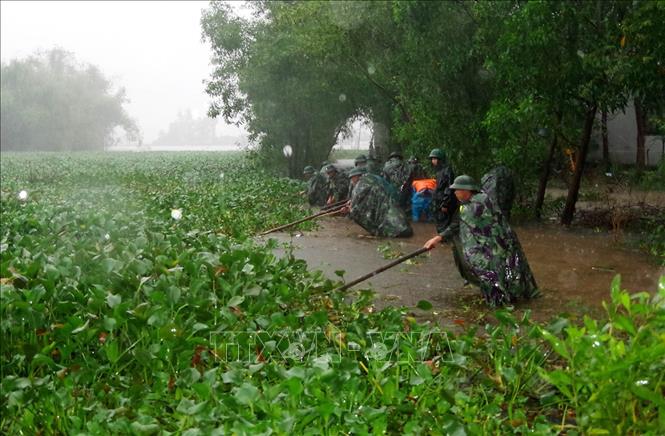 Bộ đội luôn kề vai sát cánh cùng nhân dân khắc phục hậu quả thiên tai, lũ lụt. Trong ảnh: Cán bộ, chiến sỹ Bộ Chỉ huy quân sự tỉnh Thừa Thiên - Huế giúp nhân dân vùng ngập lụt thị xã Hương Thủy thu dọn môi trường tại các trục đường dân sinh. Ảnh: Hồ Cầu - TTXVN