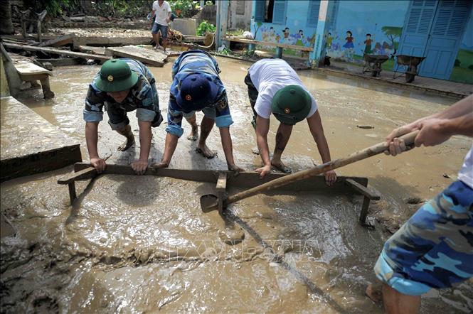 Cán bộ, chiến sĩ luôn kề vai sát cánh cùng nhân dân khắc phục hậu quả thiên tai, lũ lụt, hỏa hoạn, bài trừ hủ tục. Trong ảnh: Lực lượng quân đội tỉnh Khánh Hòa giúp các trường học dọn dẹp vệ sinh trường lớp sau trận mưa lũ lớn cuối năm 2018. Ảnh: Phan Sáu - TTXVN