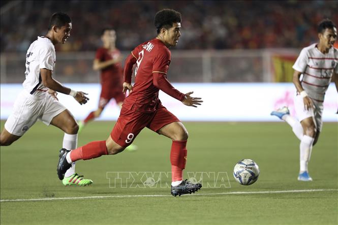 Photo: Striker Ha Duc Chinh (9) surpasses Cambodian defenders to score the second goal for Vietnam at the 26th minute. VNA Photo: Hoàng Linh