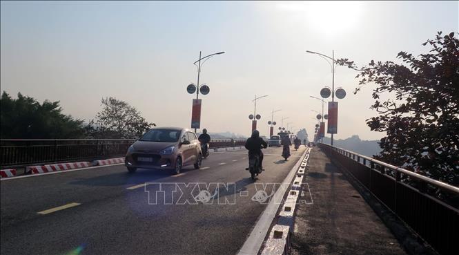 Trong ảnh: Các phương tiện tham gia giao thông đã được phép qua cầu. Ảnh Quang Đán - TTXVN