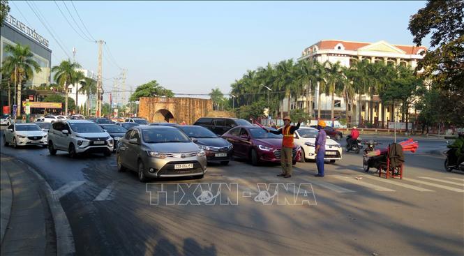 Trong ảnh: Lực lượng chức năng hướng dẫn người dân và phương tiện tham gia giao thông qua cầu. Ảnh Quang Đán - TTXVN