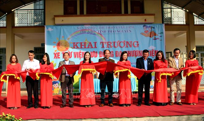 Các đại biểu cắt băng khai trương xe ô tô thư viện lưu động đa phương tiện. Ảnh: Thu Hằng - TTXVN