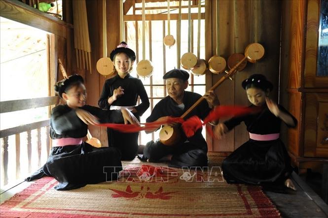 Trong ảnh: Nghệ nhân Hà Văn Thuấn truyền dạy cho cháu, chắt trong gia đình những làn điệu Then cổ. Ảnh: TTXVN