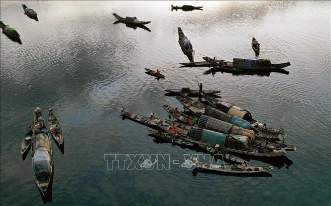 Trong ảnh: Thuyền bè của ngư dân sau một đêm đánh bắt thuỷ sản trên đầm tập trung về buôn bán trên chợ nổi Ngư Mỹ Thạnh, đầm Quảng Lợi. Ảnh: Hồ Cầu - TTXVN