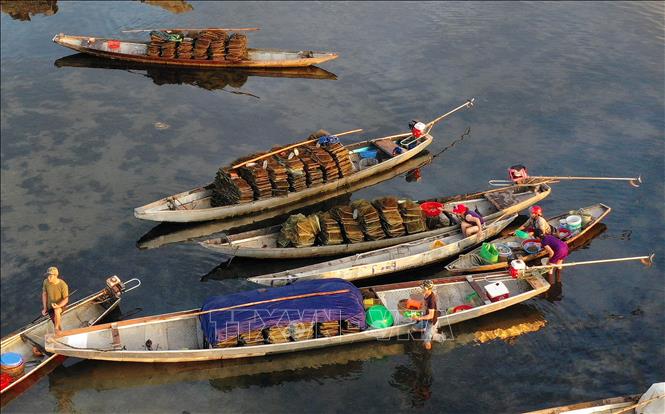 Trong ảnh: Hoạt động mua bán trên thuyền tại chợ nổi Ngư Mỹ Thạnh, đầm Quảng Lợi. Ảnh: Hồ Cầu - TTXVN