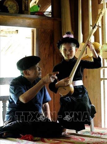 Photo: Male Then Master Ha Van Thuan (born in 1942, the Tay people) in Chiem Hoa district, Tuyen Quang province teaching the Then singing and the Tinh lute to children. VNA Photo