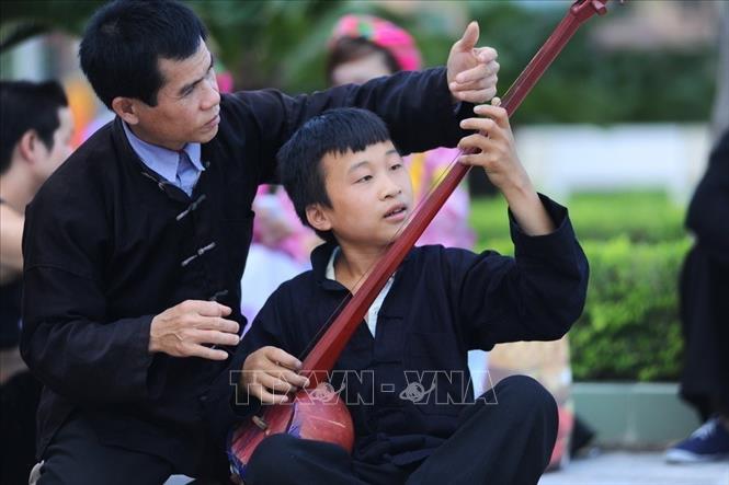 Photo: Master Hoang Duc Thang (R), in Dang hamlet, Cao Bo commune, Vi Xuyen district, Ha Giang, teaching children how to play 