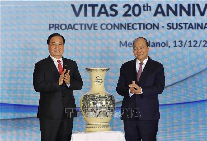 Trong ảnh: Thủ tướng Nguyễn Xuân Phúc tặng quà lưu niệm Hiệp hội dệt may Việt Nam. Ảnh: Thống Nhất – TTXVN
