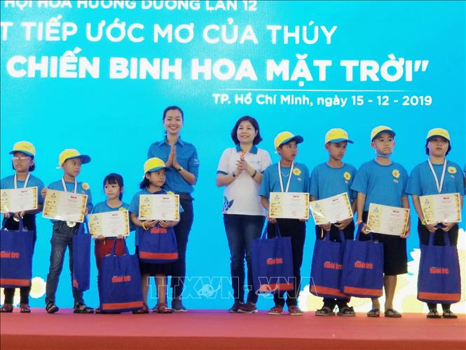 Photo: Giving 160 scholarships to children who returned to school after treatment at the event. VNA Photo: Đinh Hằng