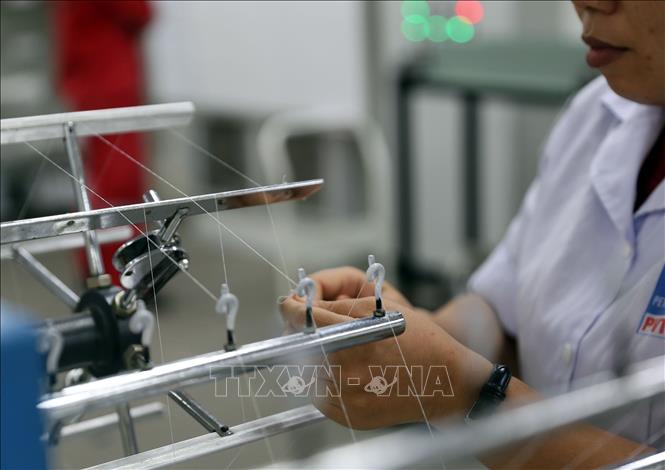 Photo: Checking the yarn at the plant's lab. VNA Photo: Huy Hùng