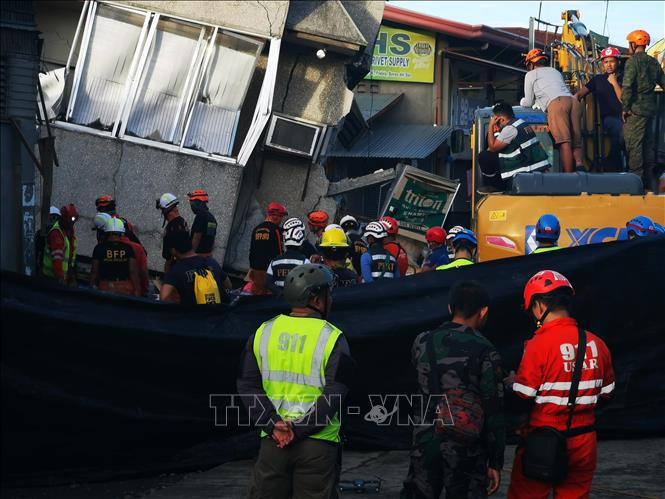 Trong ảnh: Nhân viên cứu hộ tìm kiếm nạn nhân dưới đống đổ nát của tòa nhà bị sập sau trận động đất ở đảo Mindanao, miền Nam Philippines ngày 16/12/2019. Ảnh: AFP/TTXVN