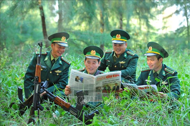 Trong ảnh: Cán bộ chiến sĩ Trạm kiểm soát biên phòng cồn Nổi giải lao đọc báo sau giờ tuần tra. Ảnh: Minh Đức - TTXVN