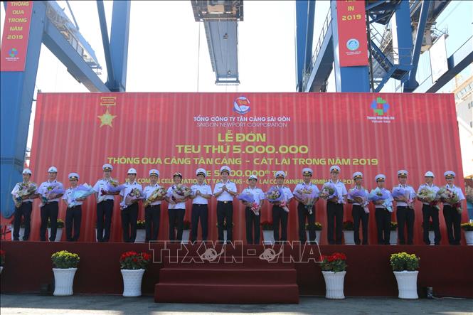 Trong ảnh: Đại tá Ngô Minh Thuấn, Tổng Giám đốc Tổng Công ty Tân Cảng Sài Gòn tặng hoa chúc mừng phát các đơn vị đã góp phần thực hiện thắng lợi đón TEU thứ 5 triệu thông qua Cảng Tân Cảng - Cát Lái. Ảnh: Thanh Vũ – TTXVN 