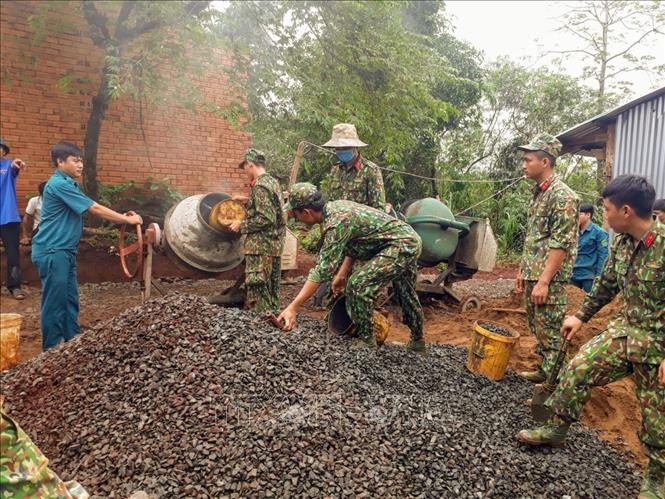 Trong ảnh: Lực lượng vũ trang và Đoàn kinh tế - Quốc phòng 778 cùng nhân dân thôn Hai Căn, Tiểu khu 119 xã Phú Nghĩa, huyện Bù Gia Mập “hợp sức” làm đường nông thôn mới. Ảnh: Dương Chí Tưởng -TTXVN