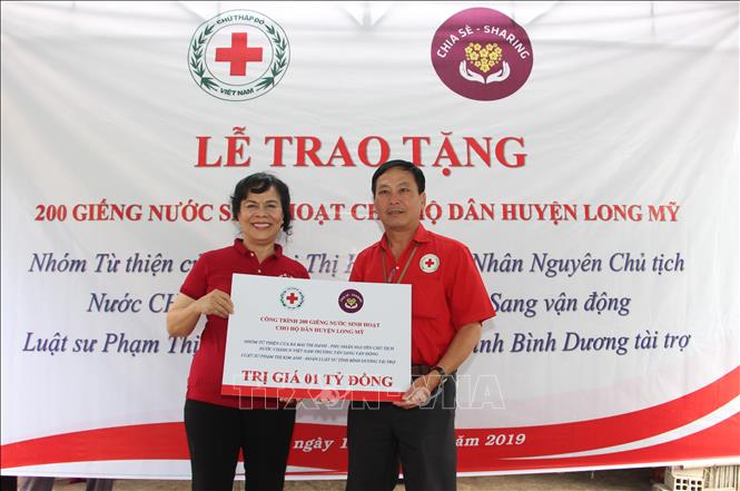 Trong ảnh: Bà Mai Thị Hạnh trao bảng tượng trưng công trình giếng nước khoan cho huyện Long Mỹ. Ảnh: Hồng Thái - TTXVN