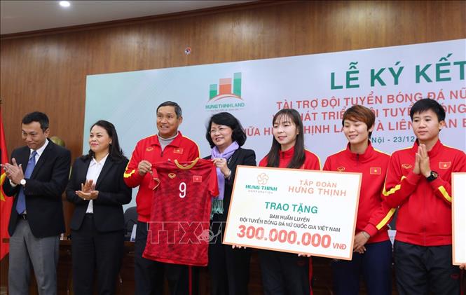 Trong ảnh: HLV trưởng Đội tuyển Bóng đá nữ Việt Nam Mai Đức Chung tặng Phó Chủ tịch nước Đặng Thị Ngọc Thịnh chiếc áo đấu có chữ ký các tuyển thủ tại buổi lễ. Ảnh: Thành Đạt - TTXVN