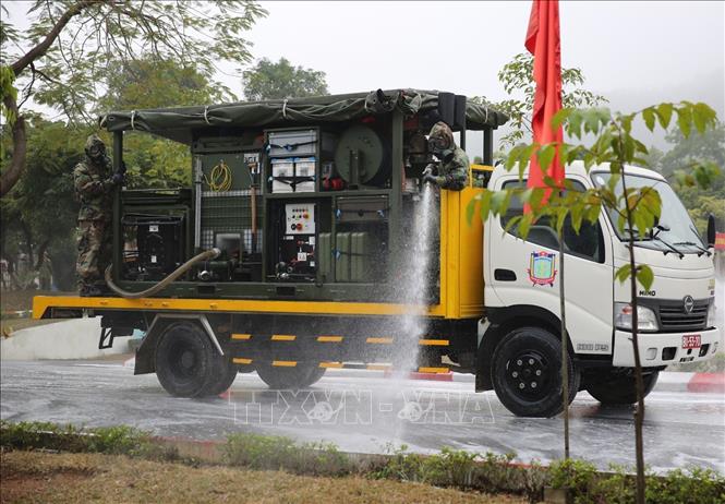 Trong ảnh: Lực lượng phòng hóa sử dụng hóa chất để tiêu tẩy khu vực nhiễm xạ. Ảnh: Dương Giang - TTXVN