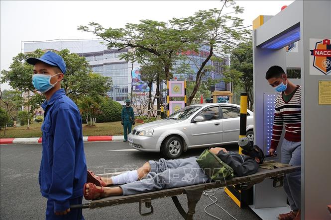 Trong ảnh: Người dân được đưa qua cổng kiểm xạ trước khi chuyển về khu tập trung. Ảnh: Dương Giang - TTXVN