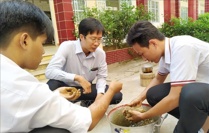 Trong ảnh: Quy trình trộn nguyên liệu chế tạo than từ vỏ sầu riêng. Ảnh: Nam Thái - TTXVN
