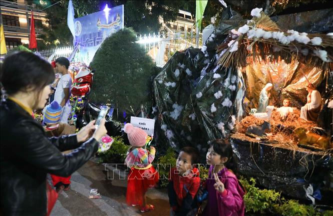 Trong ảnh: Các em nhỏ được bố mẹ đưa tới Nhà thờ Chính tòa Quy Nhơn để đón Giáng sinh. Ảnh: Thanh Tùng-TTXVN
