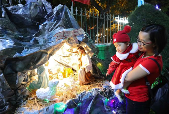 Trong ảnh: Các em nhỏ được bố mẹ đưa tới Nhà thờ Chính tòa Quy Nhơn để đón Giáng sinh. Ảnh: Thanh Tùng-TTXVN