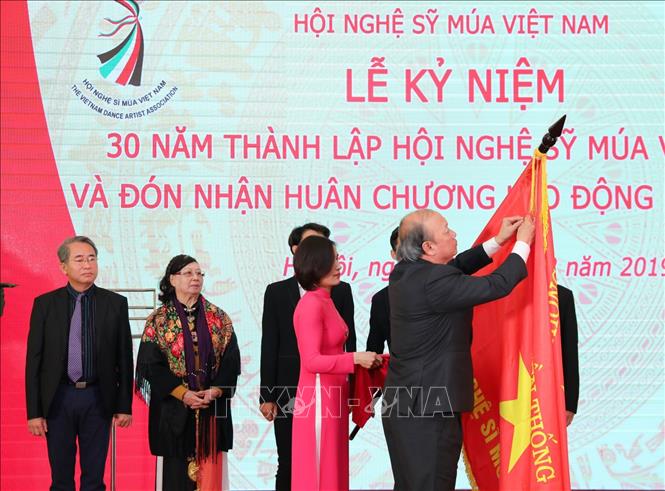 Trong ảnh: Phó Trưởng Ban Thường trực Ban Tuyên giáo Trung ương Võ Văn Phuông gắn Huân chương Lao động hạng Nhất lên cờ truyền thống của Hội nghệ sĩ Múa Việt Nam. Ảnh: Thành Đạt - TTXVN