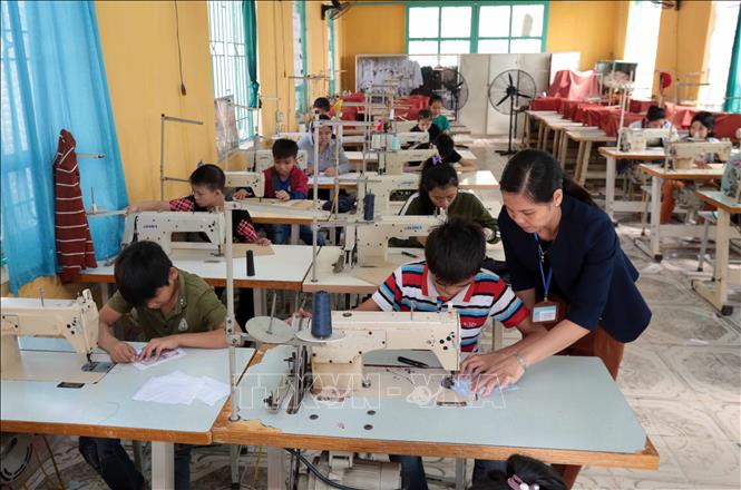 Trong ảnh: Dạy nghề may công nghiệp cho học sinh tại Trường Phục hồi chức năng và Dạy nghề cho người khuyết tật huyện Khoái Châu, Hưng Yên. Ảnh: Phạm Kiên - TTXVN