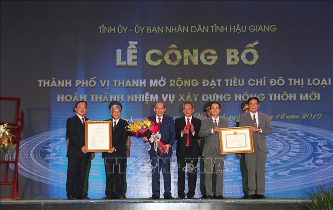 Trong ảnh: Đồng chí Trương Hòa Bình, Ủy viên Bộ Chính trị, Phó Thủ tướng Thường trực Chính phủ trao bảng công nhận thành phố Vị Thanh mở rộng đạt tiêu chí đô thị loại II và hoàn thành nhiệm vụ xây dựng nông thôn mới. Ảnh: Hồng Thái - TTXVN