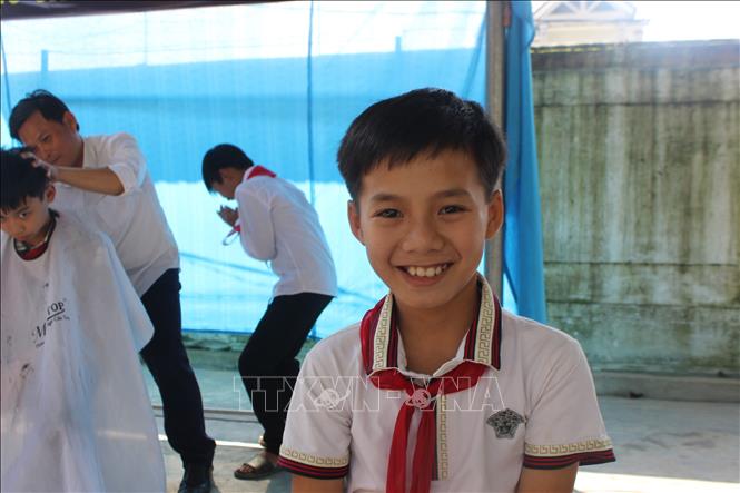 Trong ảnh: Học sinh vui mừng với mái tóc mới sau khi được các thầy giáo cắt tỉa gọn gàng. Ảnh: Hoàng Ngà - TTXVN