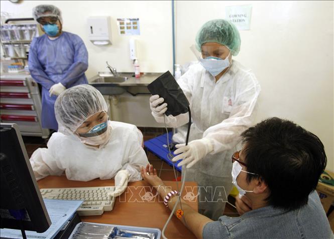 Trong ảnh: Bác sĩ kiểm tra sức khỏe cho bệnh nhân tại bệnh viện ở Singapore. Ảnh: AFP/ TTXVN