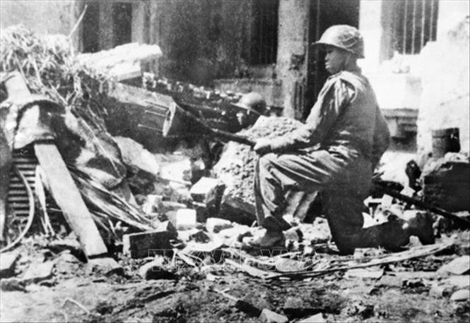 Tháng 12/1946, trước dã tâm xâm lược nước ta một lần nữa của thực dân Pháp, Đảng và Chủ tịch Hồ Chí Minh đã phát động toàn quốc kháng chiến, kêu gọi toàn dân tộc Việt Nam nhất tề đứng lên kháng chiến với quyết tâm “Quyết tử cho Tổ quốc quyết sinh”, “thà hi sinh tất cả chứ nhất định không chịu mất nước, nhất định không chịu làm nô lệ”. Trong ảnh: Đoàn viên Thanh niên cứu quốc Hoàng Diệu ôm bom ba càng, sẵn sàng tiêu diệt xe tăng địch trên đường phố Thủ đô Hà Nội những ngày đầu Toàn quốc kháng chiến, với ý chí 