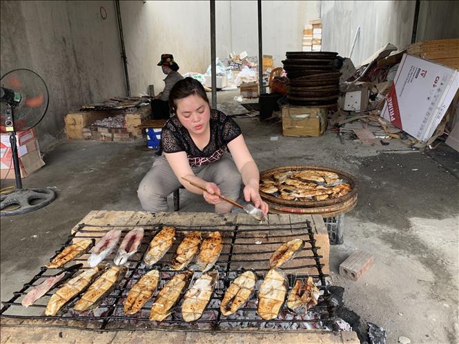 Trong ảnh: Trong quá trình nướng, cần phải giữ lửa than đượm đều để cá chín từ từ, không bị cháy. Ảnh: Khiếu Tư - TTXVN