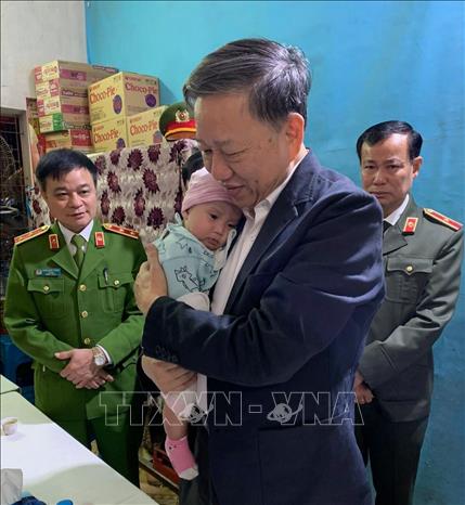 Trong ảnh: Đại tướng Tô Lâm, Bộ trưởng Bộ Công an bế cháu bé, con gái 6 tháng tuổi của Trung úy Phạm Công Huy. Ảnh: Bộ Công an/TTXVN phát