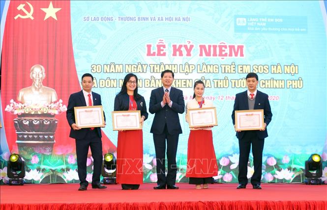 Trong ảnh: Phó Giám đốc Sở Lao động – Thương binh và Xã hội Thành phố Hà Nội Hoàng Thành Thái trao danh hiệu Chiến sỹ thi đua cho các cá nhân của Làng trẻ em SOS Hà Nội tại Lễ kỷ niệm. Ảnh: Anh Tuấn – TTXVN