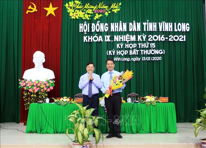 Trong ảnh: Bí thư Tỉnh ủy Vĩnh Long Trần Văn Rón (trái) tặng hoa chúc mừng tân Chủ tịch UBND tỉnh Vĩnh Long Lữ Quang Ngời. Ảnh: Phạm Minh Tuấn-TTXVN