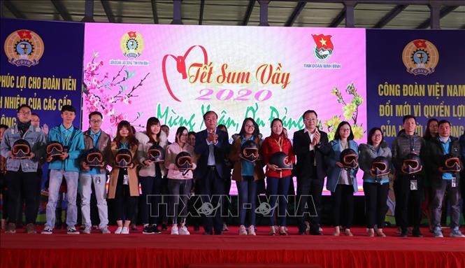 Trong ảnh: Ban tổ chức trao mũ bảo hiểm tặng công nhân. Ảnh: Đức Phương - TTXVN