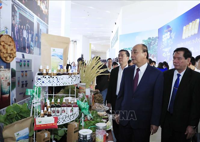Trong ảnh: Thủ tướng Nguyễn Xuân Phúc và các đại biểu thăm các gian hàng trưng bày sản phẩm tại hội nghị. Ảnh: Thống Nhất- TTXVN
