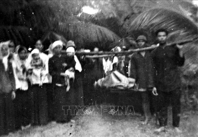 Trong ảnh: Ngày 30/12/1960, tại xã X (tỉnh Bến Tre) khiêng thi hài một người dân bị lính Ngụy bắn chết trong khi đi làm về, đấu tranh đòi địch phải bồi thường cho gia đình nạn nhân và chấm dứt việc bắn giết bừa bãi. Ảnh: Tư liệu TTXVN