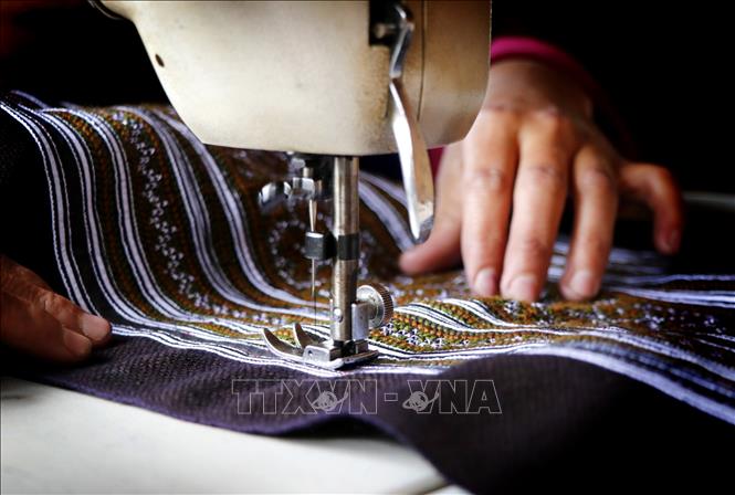Trong ảnh: Sau công đoạn dệt, người phụ nữ Mông bắt đầu công đoạn dùng kỹ thuật in, vẽ sáp và thêu để hoàn thiện sản phẩm thổ cẩm độc đáo. Ảnh: Tuấn Anh - TTXVN