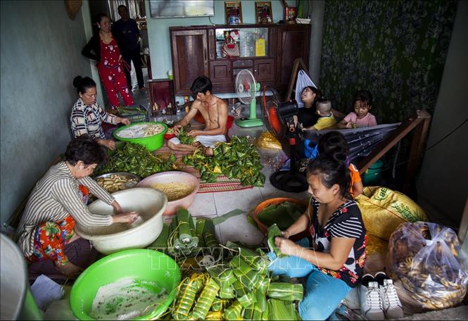 Trong ảnh: Không khí quây quần gói bánh tét phục vụ cho thị trường Tết tại một gia đình ở làng Phước Hòa. Ảnh: Hồng Đạt - TTXVN