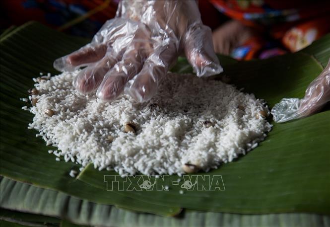 Trong ảnh: Trải gạo nếp để gói bánh tét. Ảnh: Hồng Đạt - TTXVN