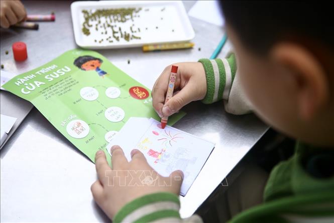 Trong ảnh: Học sinh trường Marie Curie tham gia thiết kế Lì xì hạt giống 2020, viết những lời chúc lên bao Lì xì đựng hạt giống để tặng người thân vào dịp đầu năm mới. Ảnh: Minh Quyết - TTXVN