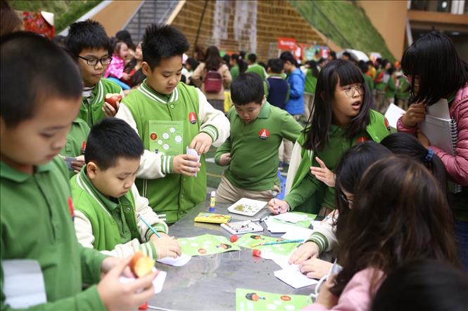 Trong ảnh: Học sinh trường Marie Curie tham gia thiết kế Lì xì hạt giống 2020, viết những lời chúc lên bao Lì xì đựng hạt giống để tặng người thân vào dịp đầu năm mới. Ảnh: Minh Quyết - TTXVN