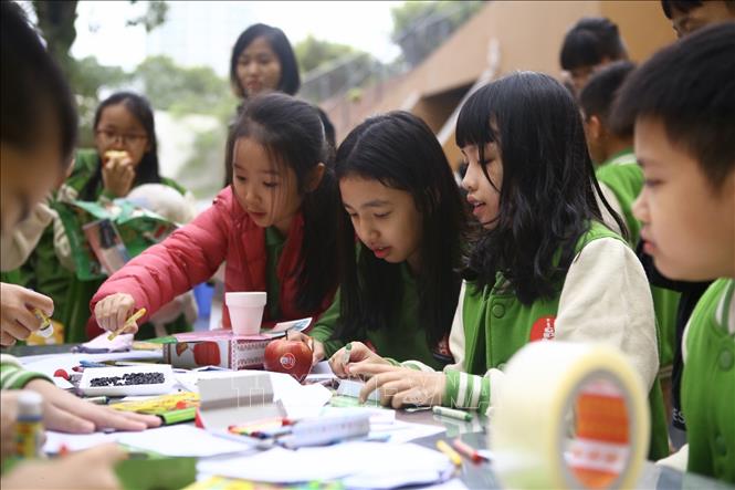 Trong ảnh: Học sinh trường Marie Curie tham gia thiết kế Lì xì hạt giống 2020, viết những lời chúc lên bao Lì xì đựng hạt giống để tặng người thân vào dịp đầu năm mới. Ảnh: Minh Quyết - TTXVN