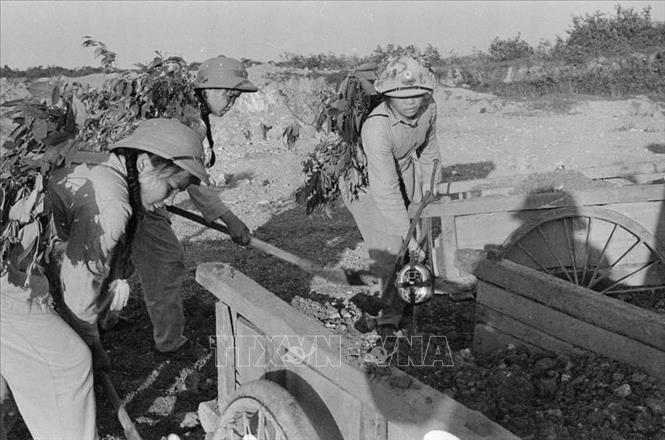 Trong thanh niên, ngày 9/8/1964, Trường Đại học sư phạm Hà Nội phát động phong trào “Ba sẵn sàng” với khẩu hiệu: Sẵn sàng chiến đấu và gia nhập lực lượng vũ trang; Sẵn sàng học tập và lao động xây dựng cuộc sống mới; Sẵn sàng đi tới nơi nào mà Tổ quốc cần đến. Trong ảnh: Nữ thanh niên xung phong Hà Tĩnh dũng cảm vừa chiến đấu, vừa đảm bảo giao thông thông suốt trên tuyến đường trọng điểm Ngã ba Đồng Lộc trong kháng chiến chống Mỹ, cứu nước. Ảnh: Văn Sắc – TTXVN
