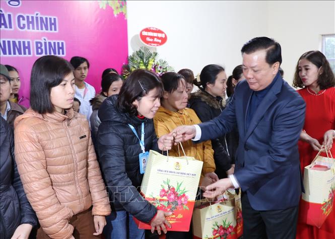 Bộ trưởng Bộ Tài chính Đinh Tiến Dũng tặng quà cho công nhân có hoàn cảnh khó khăn tại Công ty TNHH may Vạn Lợi. Ảnh: Đức Phương - TTXVN