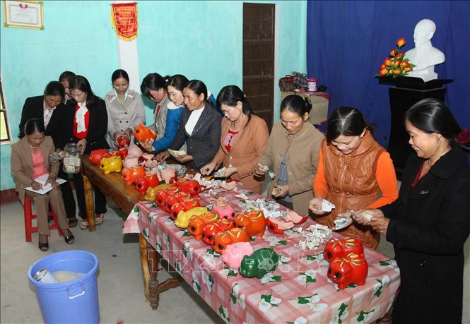 Trong ảnh: Hội viên phụ nữ huyện Cam Lộ đập lợn tiết kiệm, lấy tiền ủng hộ người nghèo. Ảnh: Hồ Cầu - TTXVN